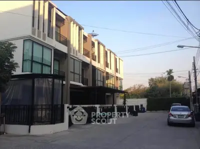 Modern townhouse exterior with multiple floors and large windows in a suburban neighborhood.