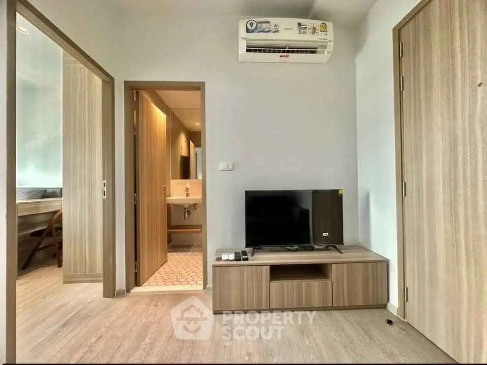 Modern living room with sleek wooden furniture and air conditioning, showcasing a minimalist design.