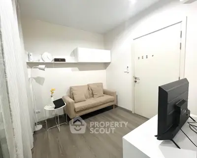Cozy living room with modern decor and neutral tones, featuring a comfortable sofa and sleek TV setup.