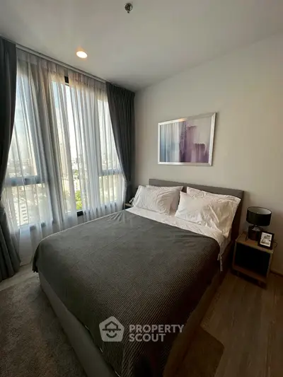 Modern bedroom with large windows and stylish decor in a high-rise apartment.