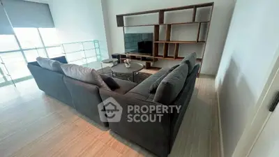 Spacious modern living room with sleek sectional sofa and stylish shelving unit.