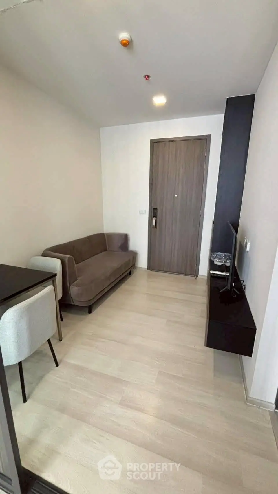 Modern living room with sleek furniture and wooden flooring in a stylish apartment.