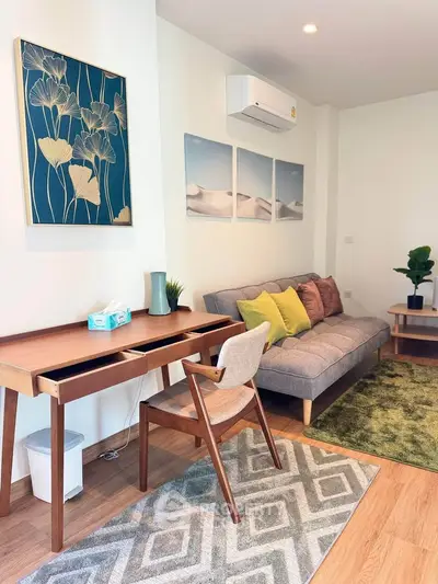 Stylish living room with modern decor, featuring a cozy sofa, elegant artwork, and wooden furniture.