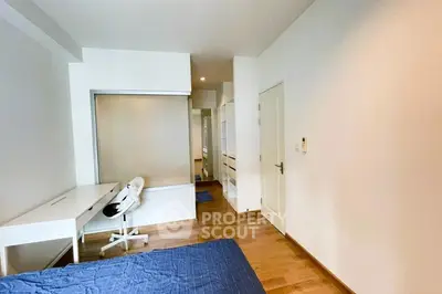 Modern bedroom with wooden flooring and study desk, perfect for a cozy living space.