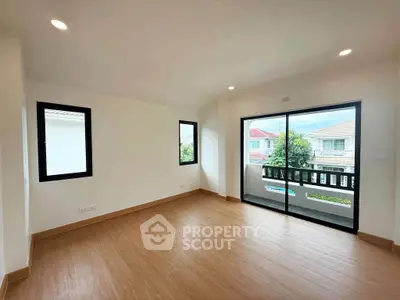 Spacious living room with large windows and balcony access, offering a bright and airy atmosphere.