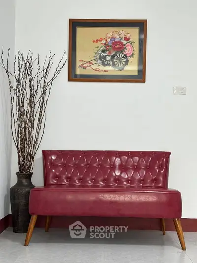 Stylish red leather bench with floral artwork in modern interior design.