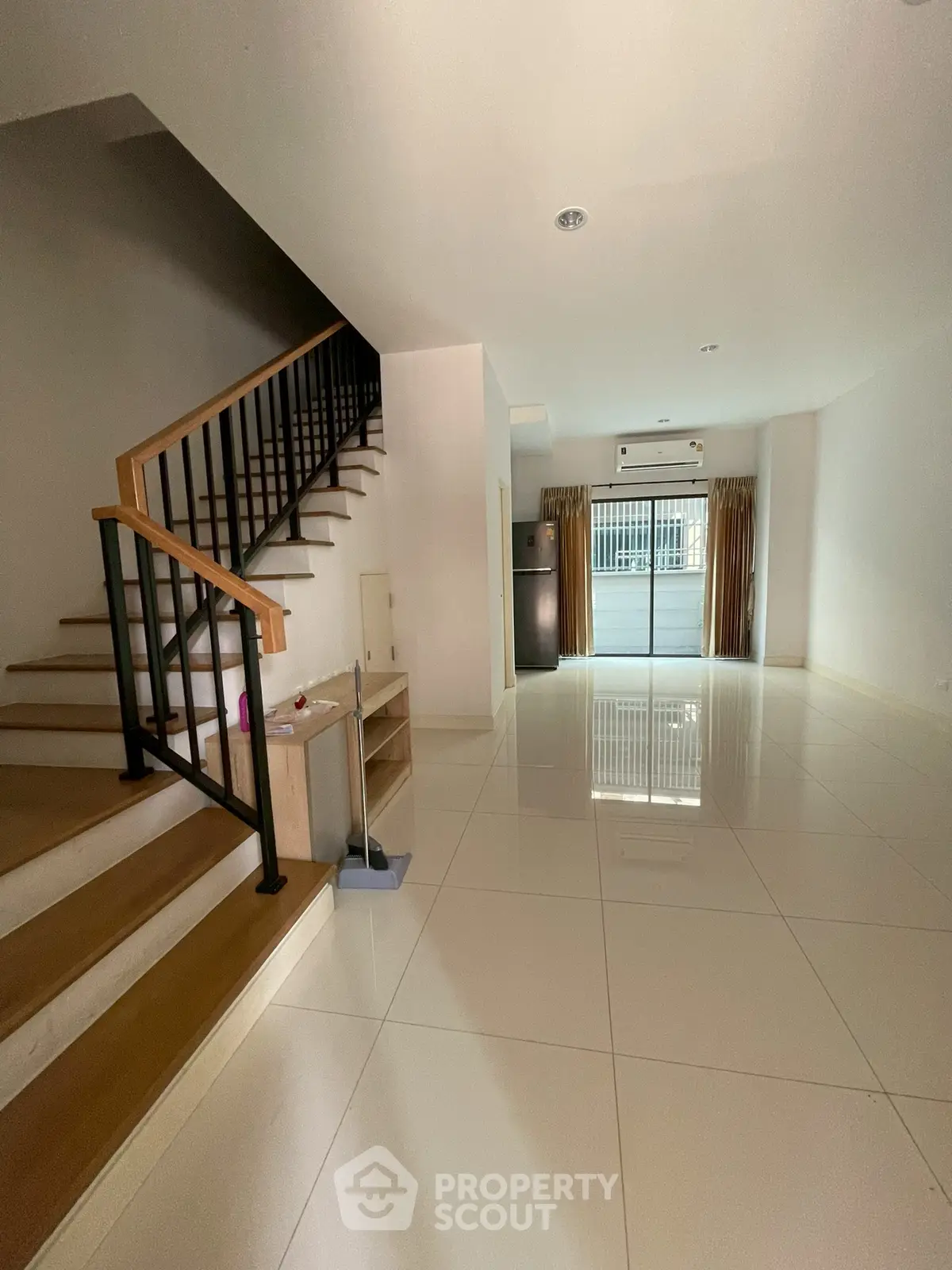 Spacious modern living room with staircase and large windows for natural light