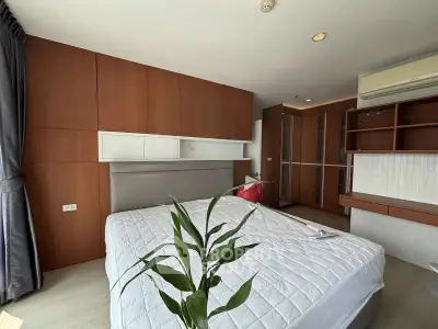 Spacious bedroom with modern wooden cabinetry and large window for natural light.