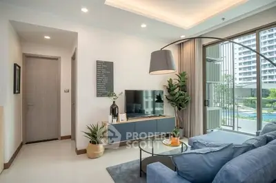 Modern living room with large windows and pool view, featuring stylish decor and comfortable seating.