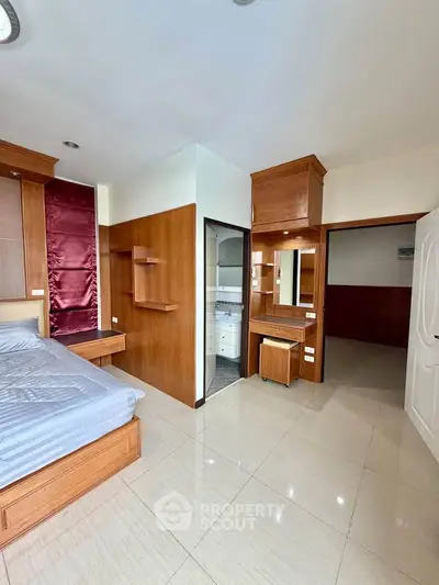 Spacious bedroom with built-in wooden furniture and modern design