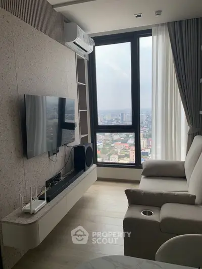 Modern living room with city view, sleek furniture, and wall-mounted TV.