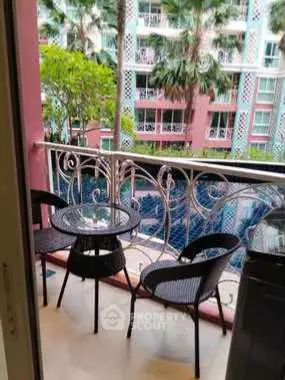 Charming balcony with pool view in a vibrant residential complex.