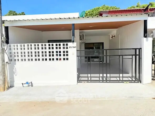 Charming single-story home with modern facade and gated entrance, perfect for cozy living.
