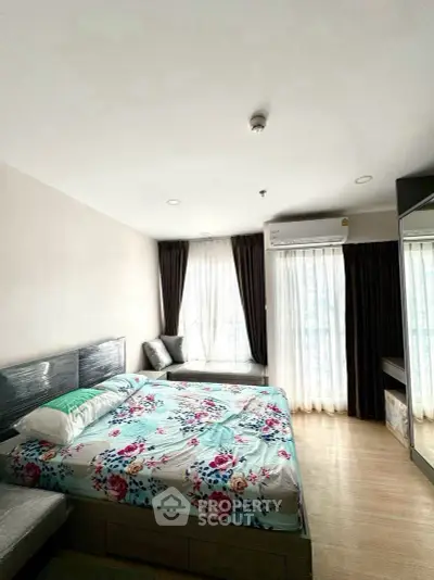 Bright and cozy bedroom with large windows and modern furnishings, perfect for relaxation.