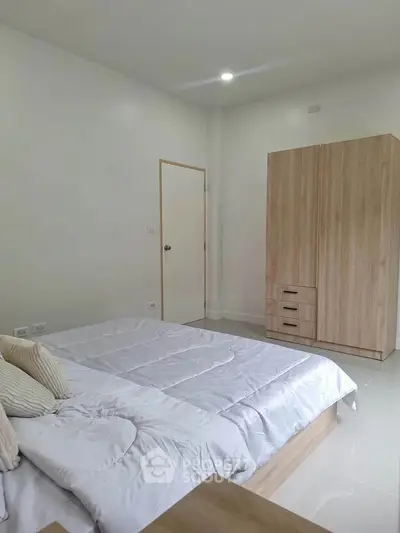 Spacious bedroom with modern wooden wardrobe and cozy bedding