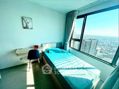 Bright bedroom with city view, featuring a single bed and study desk, perfect for urban living.