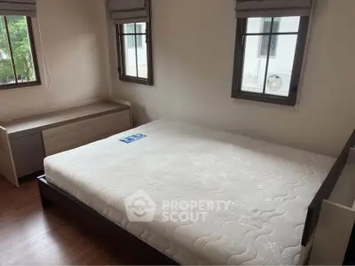 Spacious bedroom with large windows and modern furniture, perfect for natural light lovers.