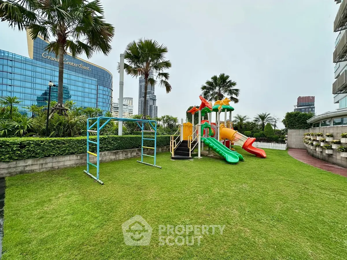 Luxurious residential complex with lush garden and modern playground, perfect for family living in urban setting.