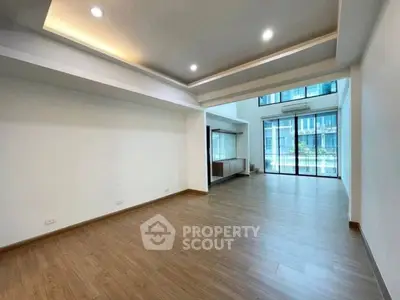 Spacious modern living room with wooden flooring and large windows