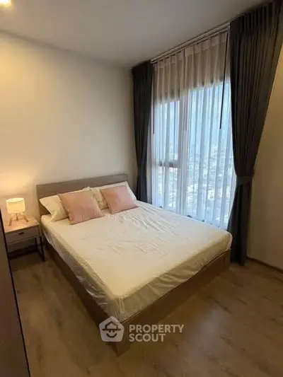 Cozy bedroom with large window and elegant curtains