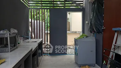 Modern outdoor kitchen with sleek countertops and washing machine, perfect for convenient living.