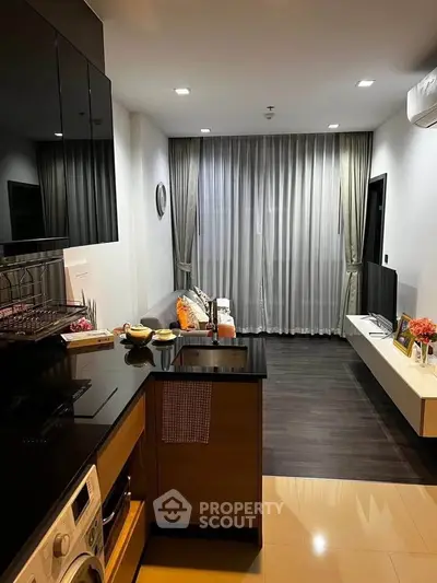 Modern open-layout kitchen and living room with sleek design and cozy ambiance.