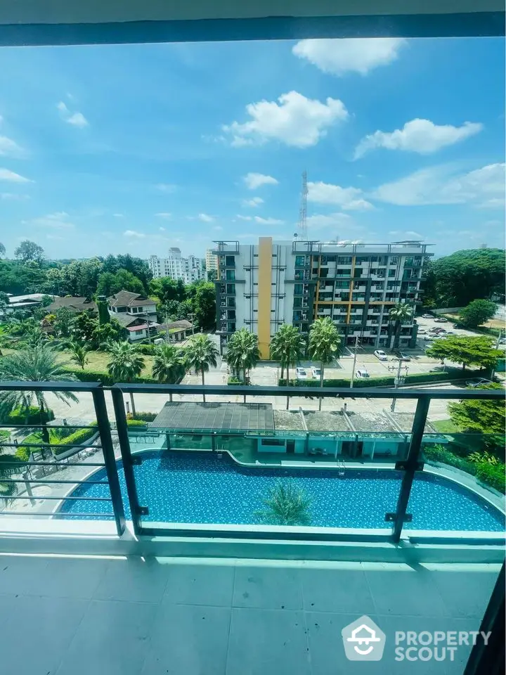 Stunning balcony view overlooking a luxurious pool and modern cityscape.