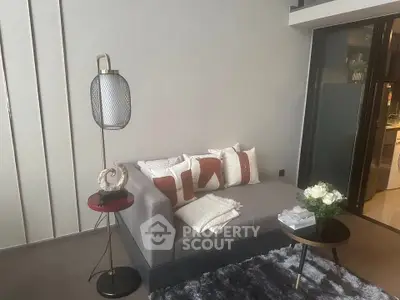 Modern living room with stylish gray sofa, chic floor lamp, and cozy decor accents.