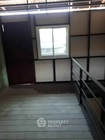 Industrial-style interior with metal railing and window, showcasing modern design elements.