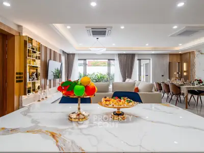 Luxurious open-plan living room with elegant decor and marble accents