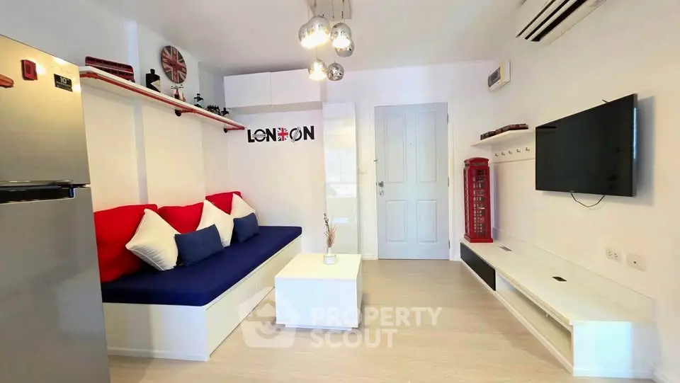 Modern living room with stylish decor and wall-mounted TV in a cozy apartment.