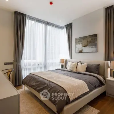 Luxurious modern bedroom with large windows and elegant decor in a high-rise apartment.