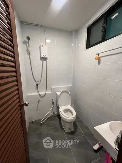 Modern bathroom with shower and toilet in sleek tiled design