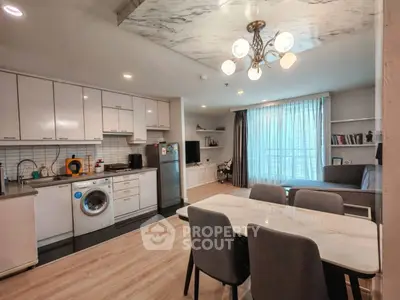 Modern open-layout kitchen and living room with stylish decor and natural light.