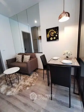 Modern living room with cozy seating and dining area, featuring stylish decor and warm lighting.