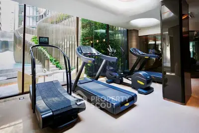 Luxurious gym with modern treadmills and scenic outdoor view in upscale residential building.