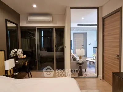 Elegant bedroom with sliding glass doors leading to a cozy balcony, showcasing modern furnishings and a serene atmosphere.