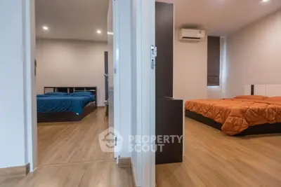 Spacious modern bedroom with wooden flooring and cozy ambiance
