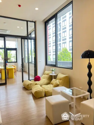 Modern living room with large windows and stylish furniture in a contemporary apartment.