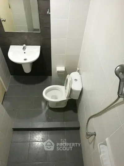 Compact bathroom with modern fixtures and shower in a real estate property.
