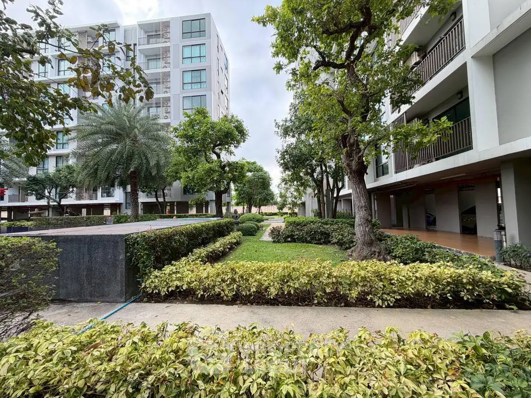 Modern apartment complex with lush landscaped gardens and contemporary architecture.