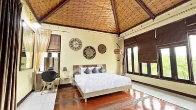 Spacious bedroom with elegant decor and large windows offering natural light and scenic views.
