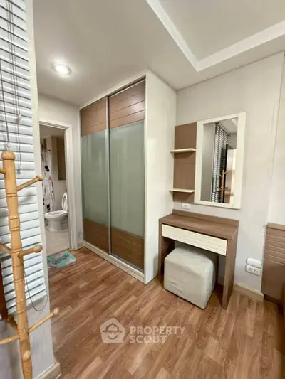 Modern bedroom with wooden flooring and built-in wardrobe