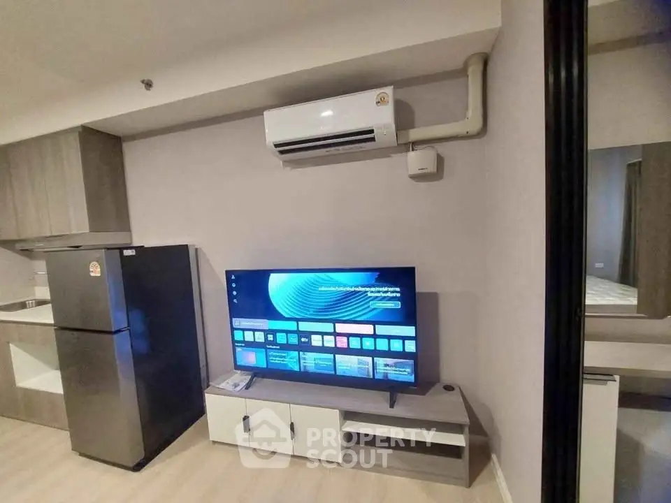 Modern living room with sleek TV setup and air conditioning in stylish apartment.