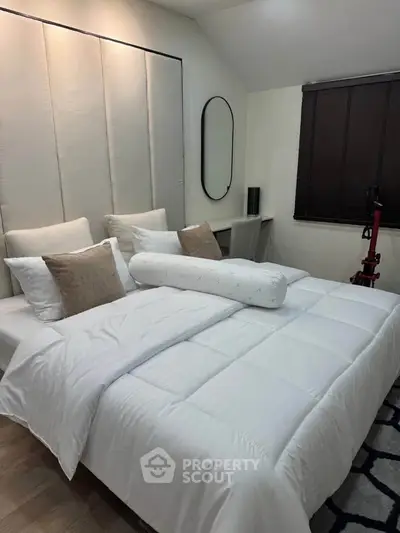 Cozy bedroom with plush bedding and modern decor, perfect for relaxation.