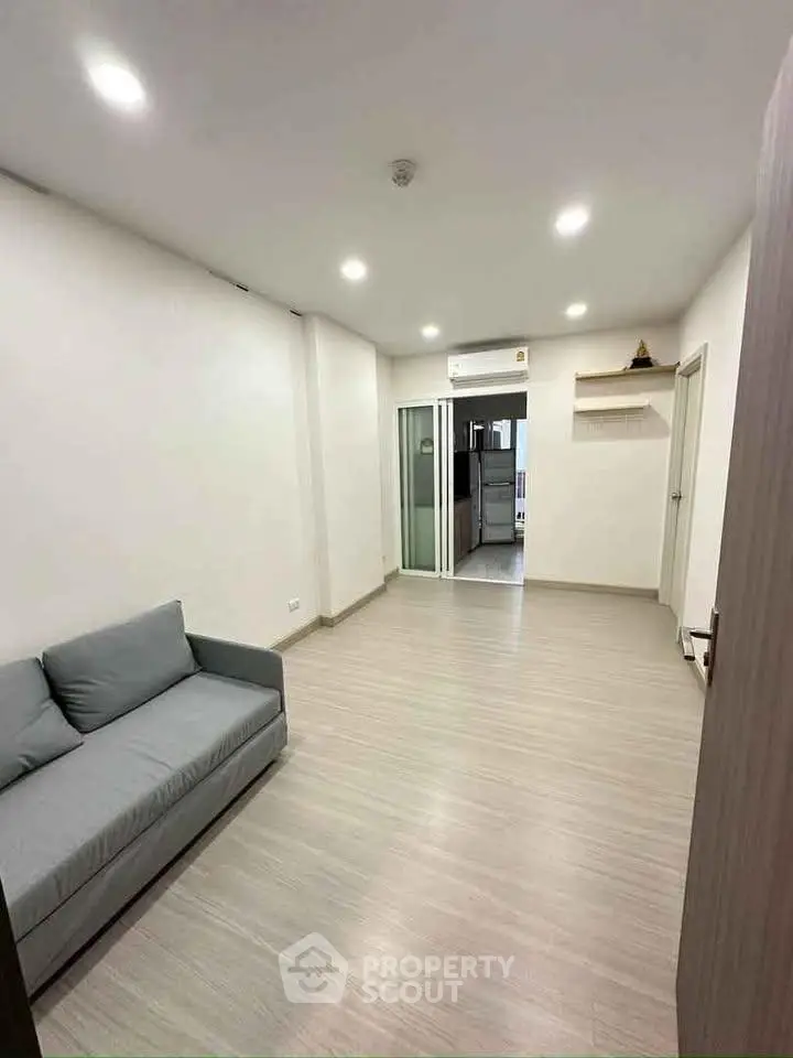 Spacious living room with modern sofa and sleek flooring in a contemporary apartment.