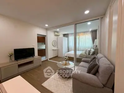 Modern studio apartment with cozy living area and bedroom, featuring stylish decor and natural light.