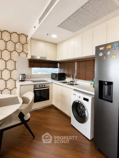 Modern kitchen with sleek appliances and stylish decor, featuring a washing machine and oven.