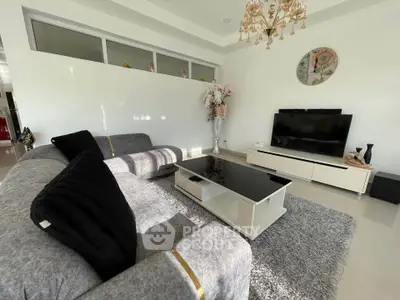 Elegant living room with modern decor, plush gray sofa, and large flat-screen TV.