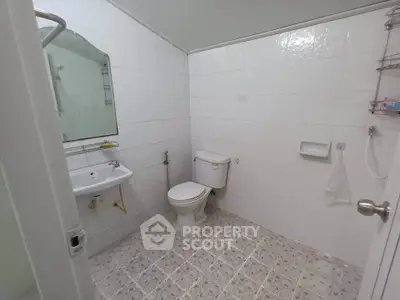 Spacious bathroom with modern fixtures and tiled flooring, perfect for comfort and convenience.